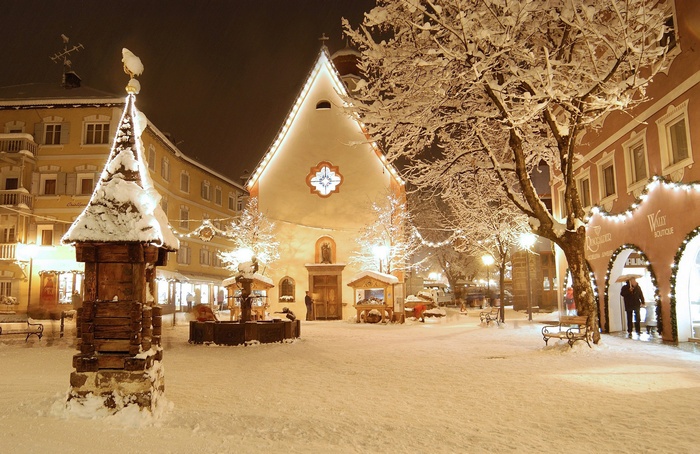 Snowy Christmas town square with church and fountain