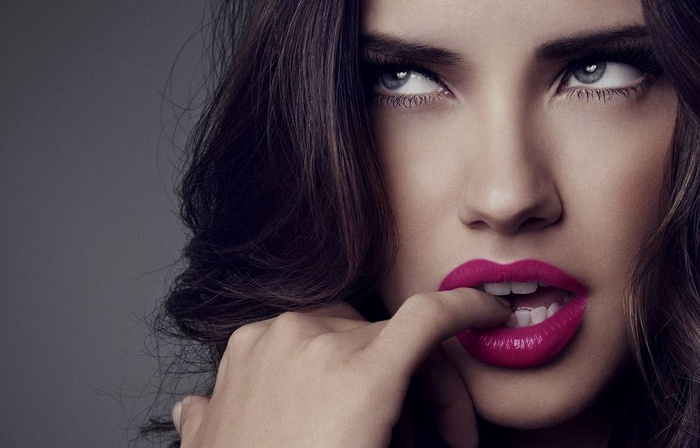 Adriana Lima biting her finger with pink lipstick