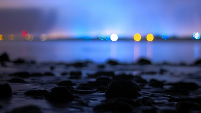 Bokeh lights over calm water at night