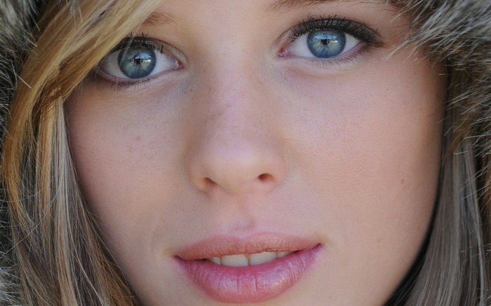 Close-up of a young woman with blonde hair and blue eyes