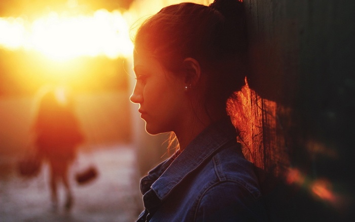 Woman in denim jacket at sunset