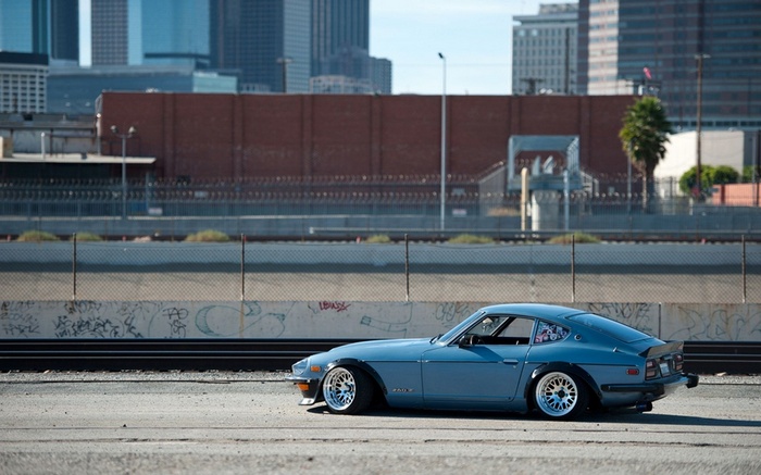 Blue Datsun 240Z parked in an urban setting