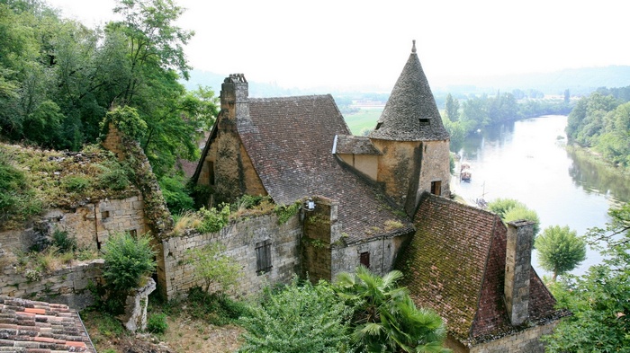 Overgrown ruins of a house by a river