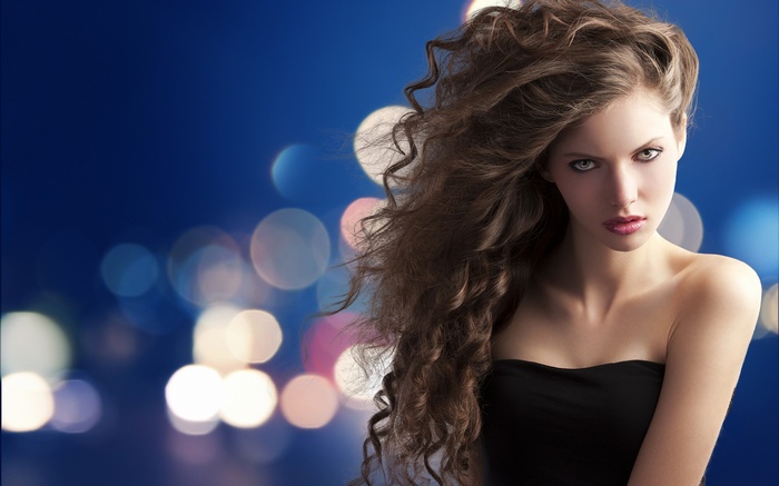 Brunette model with curly hair and bare shoulders