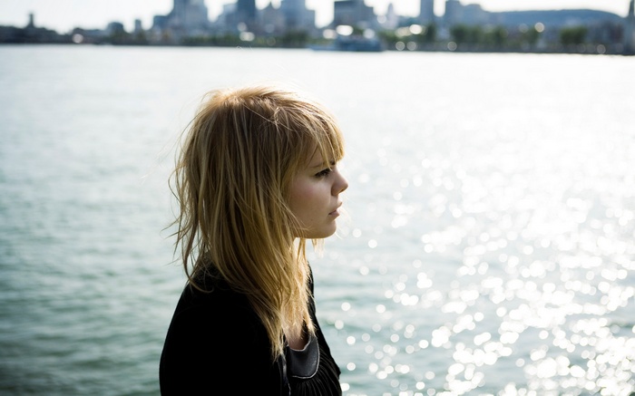 Coeur De Pirate looking out over a city and water
