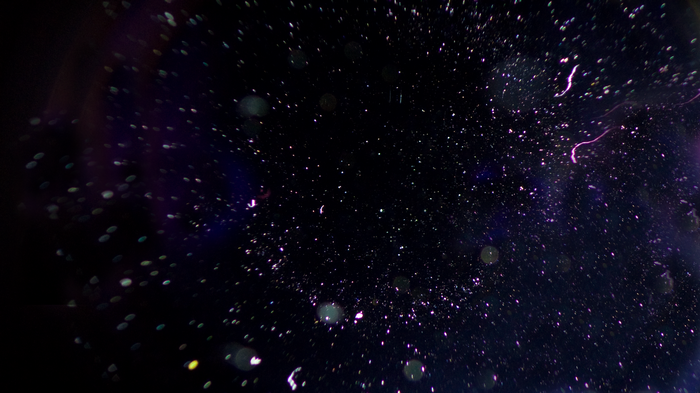 Abstract dark background with purple and white particles