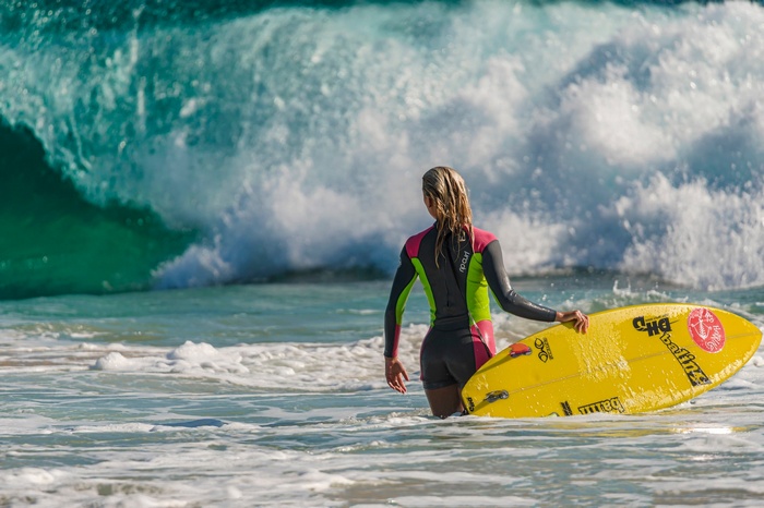 Woman with surfboard in ocean waves