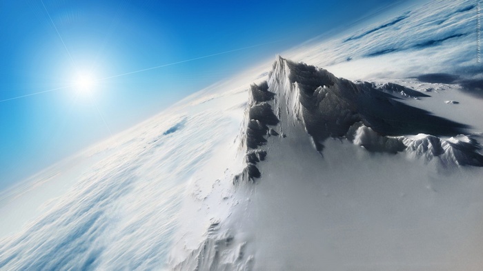 Snowy mountains on Earth from space with sun