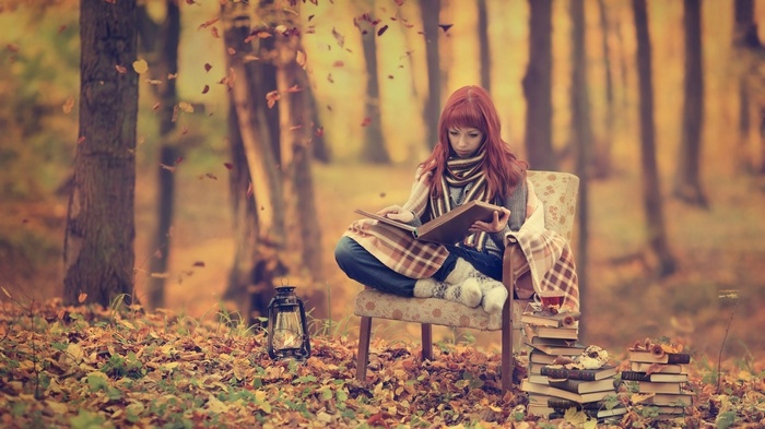 Woman reading a book in an autumn forest