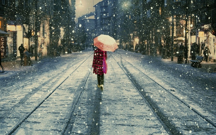Woman with umbrella walks in snowy Eskişehir street