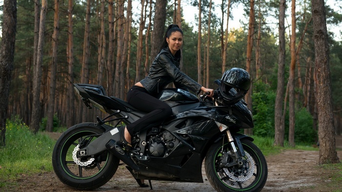 Woman on a black Kawasaki Ninja ZX6R motorcycle in a forest