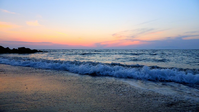 Ocean waves on a beach at sunset