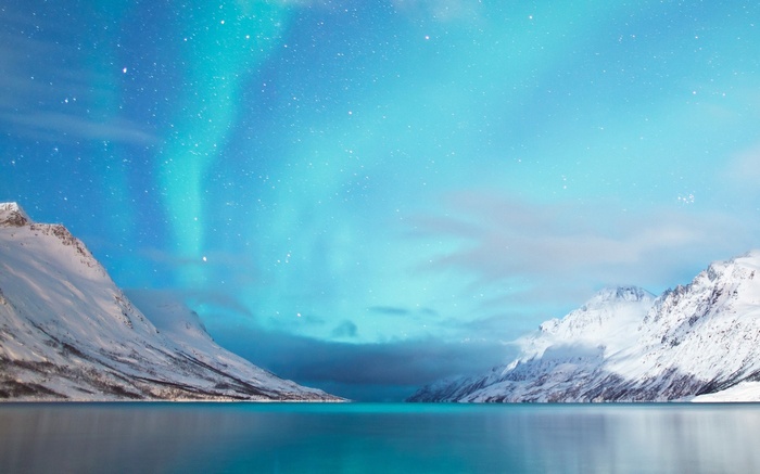 Snowy mountains under the aurora borealis