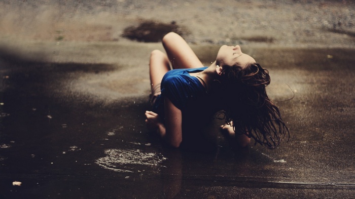 Woman in blue shirt sitting in the rain