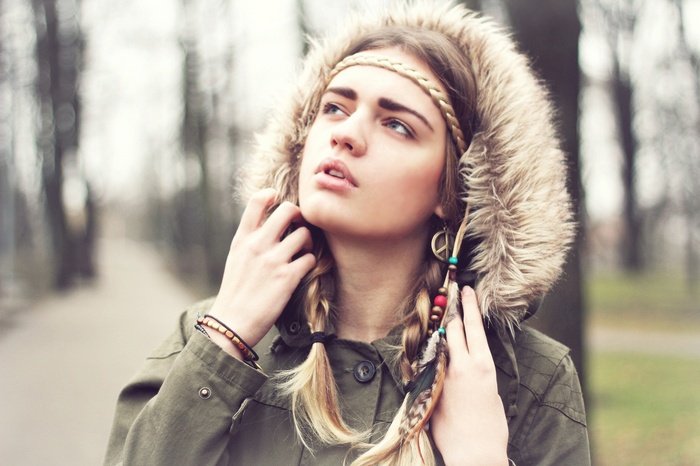 Young woman with blonde braids and hippie accessories outdoors