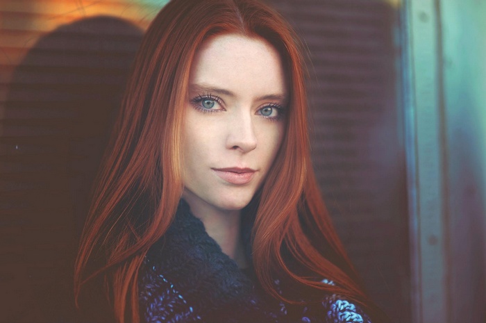 Portrait of a woman with long red hair and blue eyes