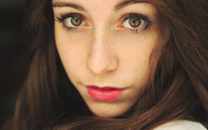 Close-up portrait of a young woman with freckles