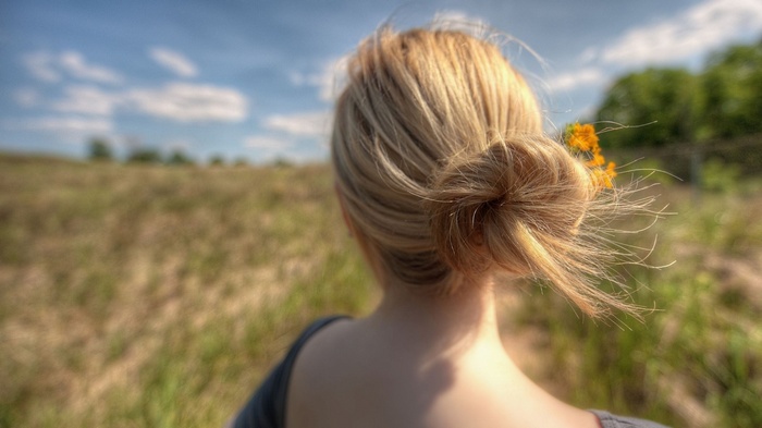 Woman with blonde hair in a bun outdoors