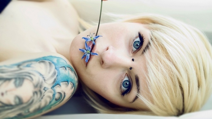 Woman with blonde hair and blue eyes with flowers