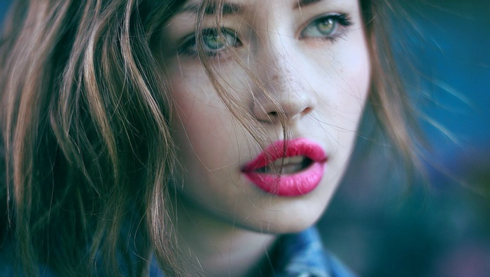 Close-up portrait of a young woman with bright pink lipstick