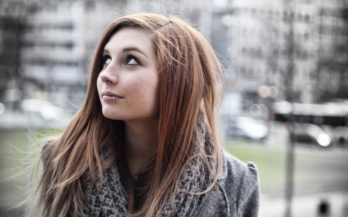 Woman with piercings looking up outdoors