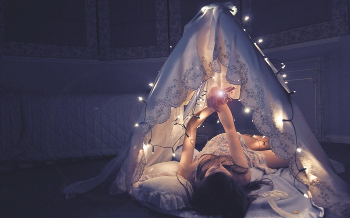 Woman in a tent with fairy lights