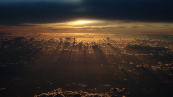 Sunbeams breaking through dark clouds from above