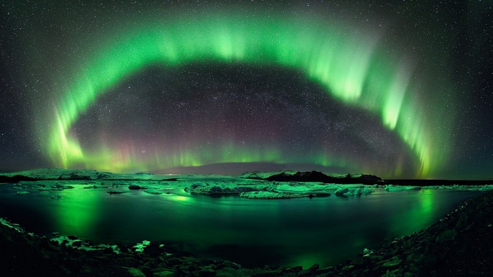 Aurora Borealis over a glacial lagoon at night