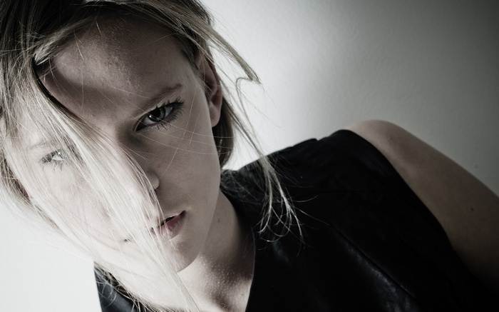 Model with blonde hair in face, close-up portrait