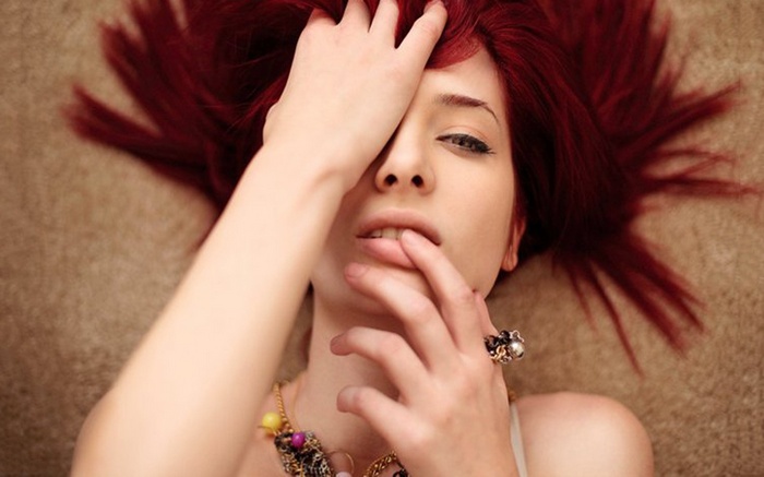 Susan Coffey with red hair lying down