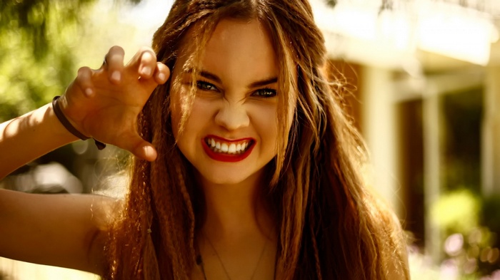 Liana Liberato with hand raised in a claw-like gesture