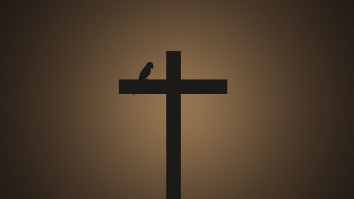 Silhouette of a bird on a cross