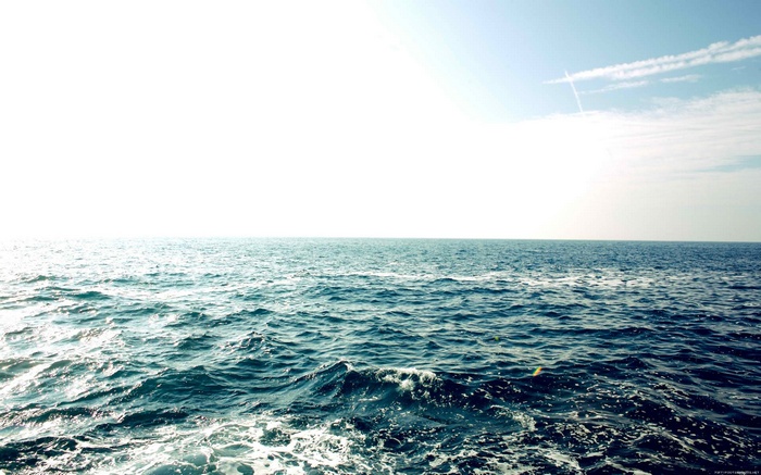 Ocean waves under a bright sky