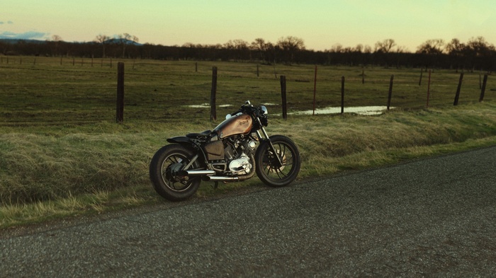 Bobber motorcycle parked on the side of a rural road