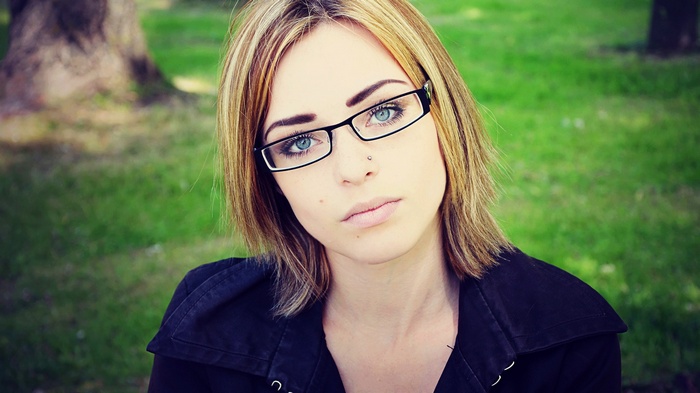 Woman with glasses and nose piercing outdoors