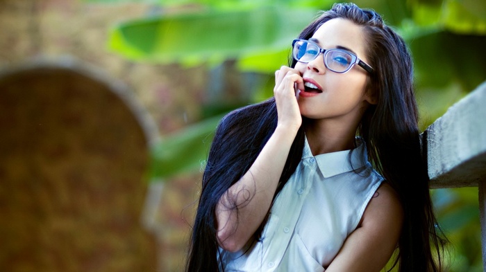 Woman with long dark hair and glasses