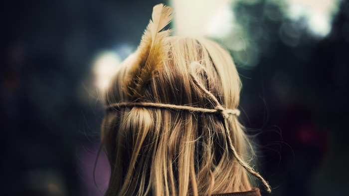 Woman with blonde hair and feather headband