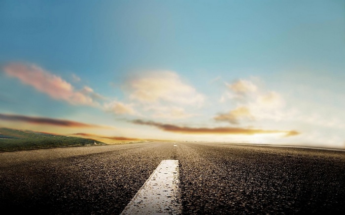Road stretching towards the horizon under a cloudy sky