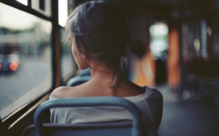 Woman looking out of a bus window