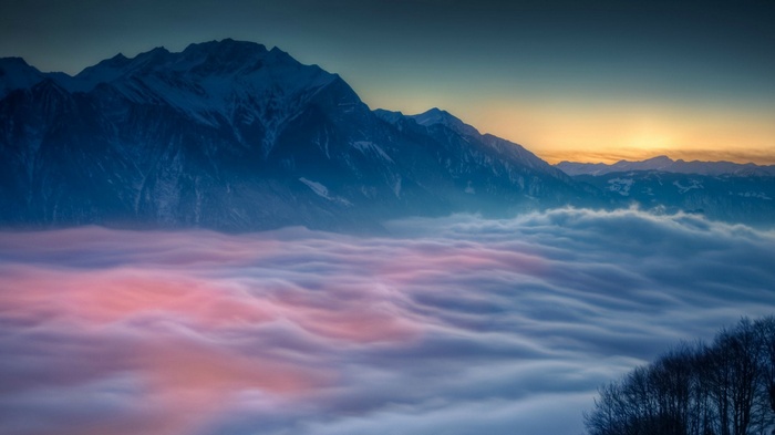 Mountains above clouds at sunrise
