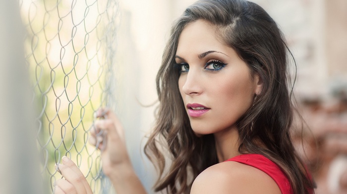 Woman in red dress behind a fence