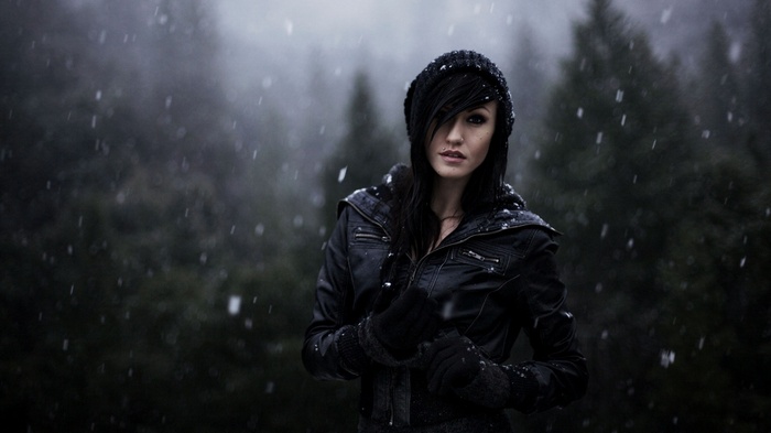 Woman in black beanie and leather jacket in snow