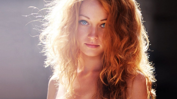 Redhead woman with blue eyes in sunlight