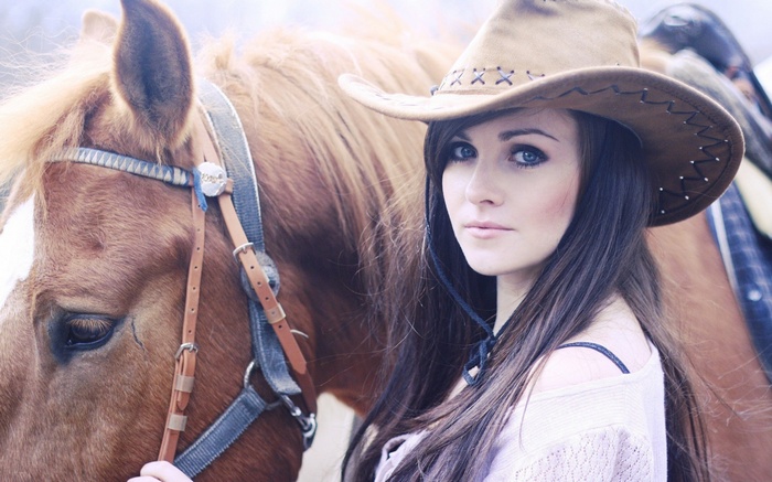 Woman in cowboy hat with horse