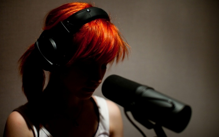 Hayley Williams wearing headphones in front of a microphone