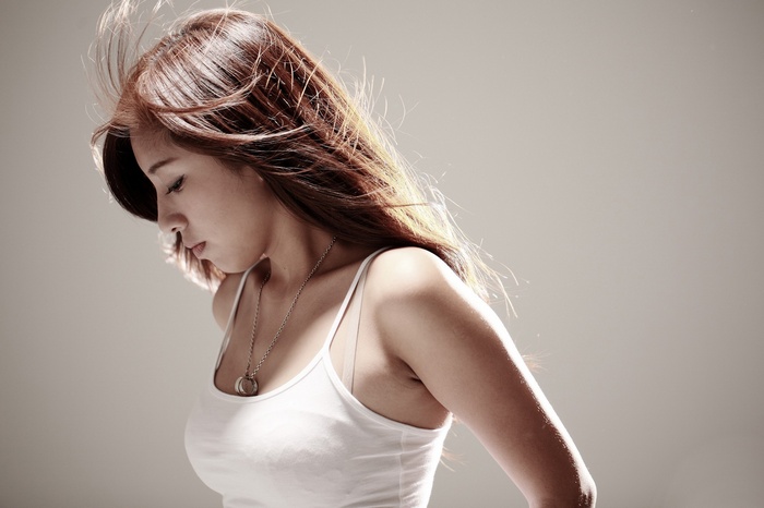 Woman in white tank top with necklace