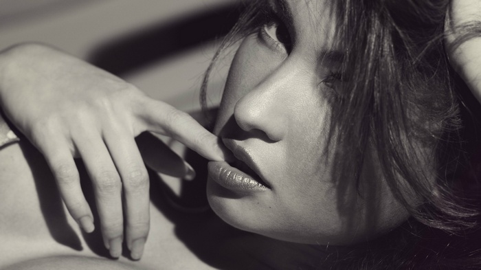 Woman biting her finger, monochrome portrait