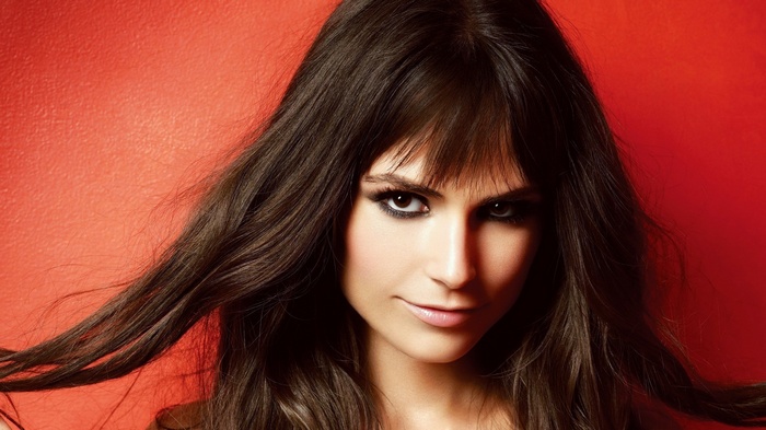 Jordana Brewster portrait with dark hair and red background