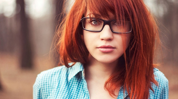 Redhead woman with glasses wearing a blue checkered shirt