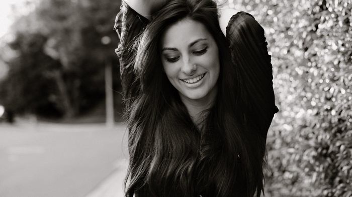 Monochrome portrait of a smiling woman with long hair